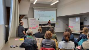 Projektleiterin spricht vor versammelter Gruppe.